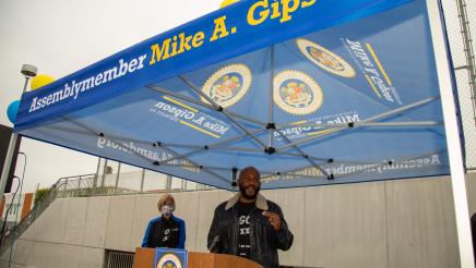 Asm. Gipson at podium, speaking to volunteers