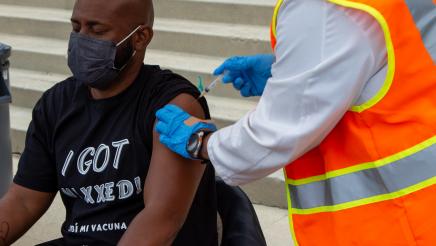 Asm. Gipson seated, receiving vaccination