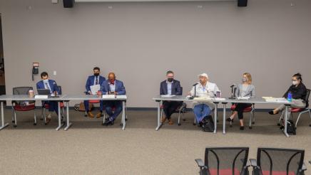Panelists seated at tables
