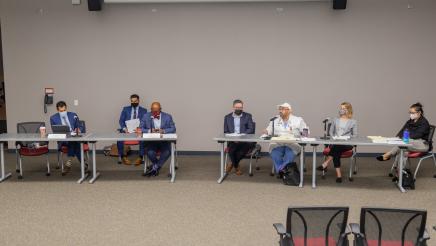 Panelists seated at tables