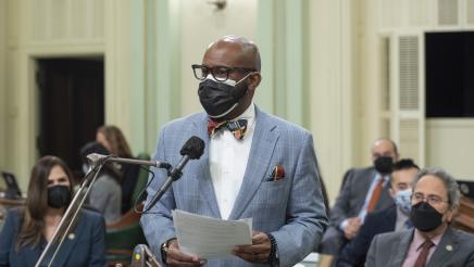 Asm. Gipson standing at microphone, addressing the Assembly