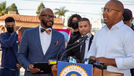 Assemblymember Gipson and other local leaders watch Long Beach Vice Mayor Rex Richardson as he stands at a podium.
