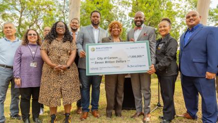 Group photo with large check being held at center