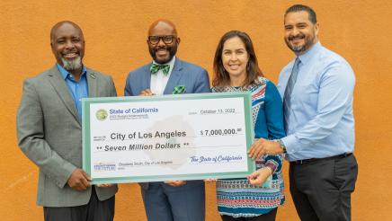 Group photo with large ceremonial check held at center