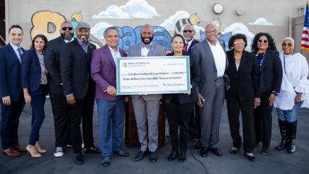 Group photo with large check held at center
