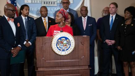 Moms Demand Action representative  at podium, speaking with Asm. Gipson