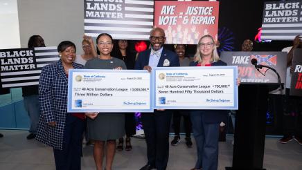 Asm. Gipson, Jade Stevens and Julie Alvis holding large checks