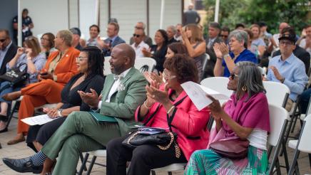 Asm. Gipson and seated attendees applauding