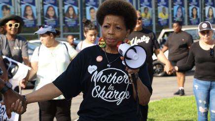 Woman holds megaphone while holding hands with fellow participant
