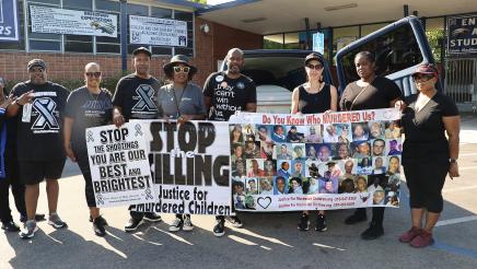 Asm. Gipson and others holding up banners