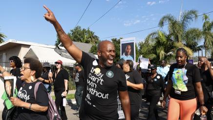Asm. Gipson shouting and pointing forward while marching with fellow participants