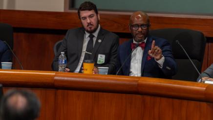 Asm. Gipson holds up hand and pointer finger while addressing witness