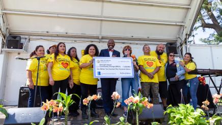Asm. Gipson and SBCC staff on stage, holding up large ceremonial check