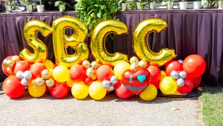 Many ballons on ground, some spelling out "SBCC"