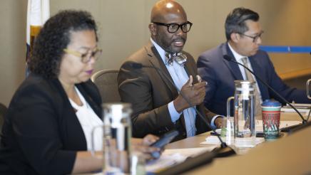 Asm. Gipson, seated with other committee members, speaking