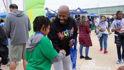 Asm. Gipson congratulating child participant