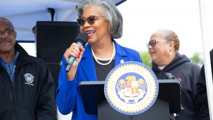 Guest speaker holding microphone, speaking