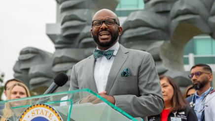 Asm. Gipson at podium, speaking, with hospital staff in background