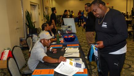 Father at resource table, being provided with informational materials