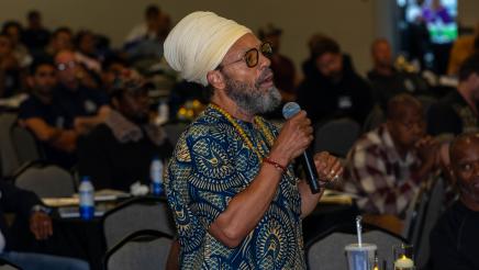Audience member standing, speaking into microphone