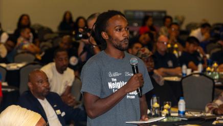 Audience member standing, speaking into microphone