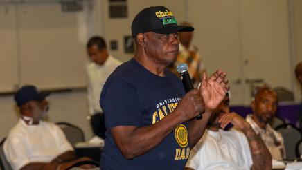 Audience member standing, speaking into microphone