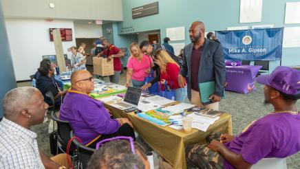 Asm. Gipson speaking with volunteers at resource table
