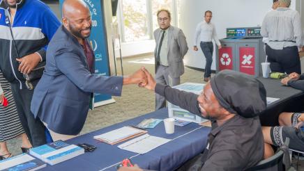 Asm. Gipson shaking hands and sharing a light moment with table staffer