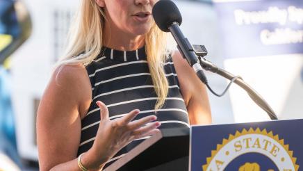 Guest speaker at podium, speaking and gesturing with one hand