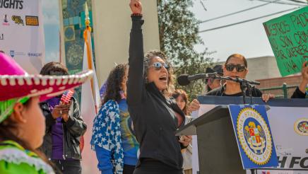 Guest speaker at podium, holding up small U.S. flag