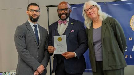 Asm. Gipson with guest speakers, holding signed bill
