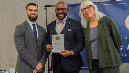 Asm. Gipson with guest speakers, holding signed bill