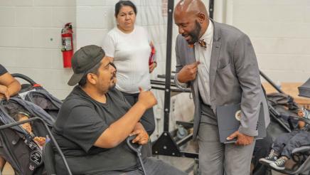 Asm. Gipson speaking with constituent seated in electric scooter