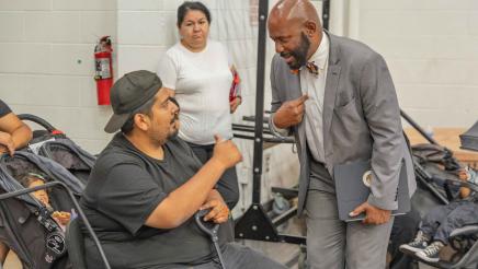 Asm. Gipson speaking with constituent seated in electric scooter
