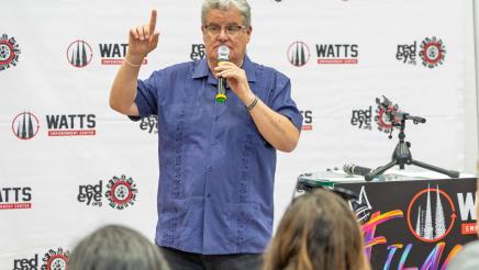 Honoree standing, speaking and holding up one finger