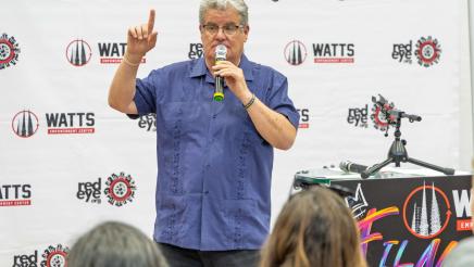 Honoree standing, speaking and holding up one finger