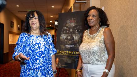 Special guests speaking in front of Respect My Crown poster