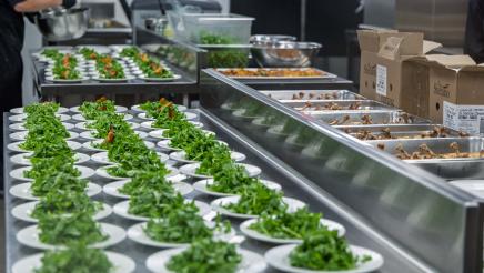 Multiple plates of salad being prepared