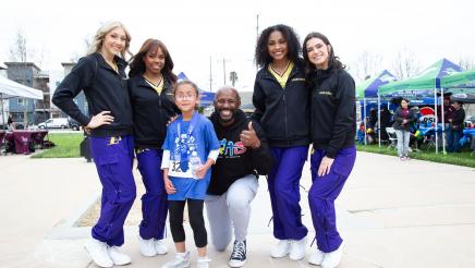 Asm. Gipson and child with LA Lakers cheerleaders